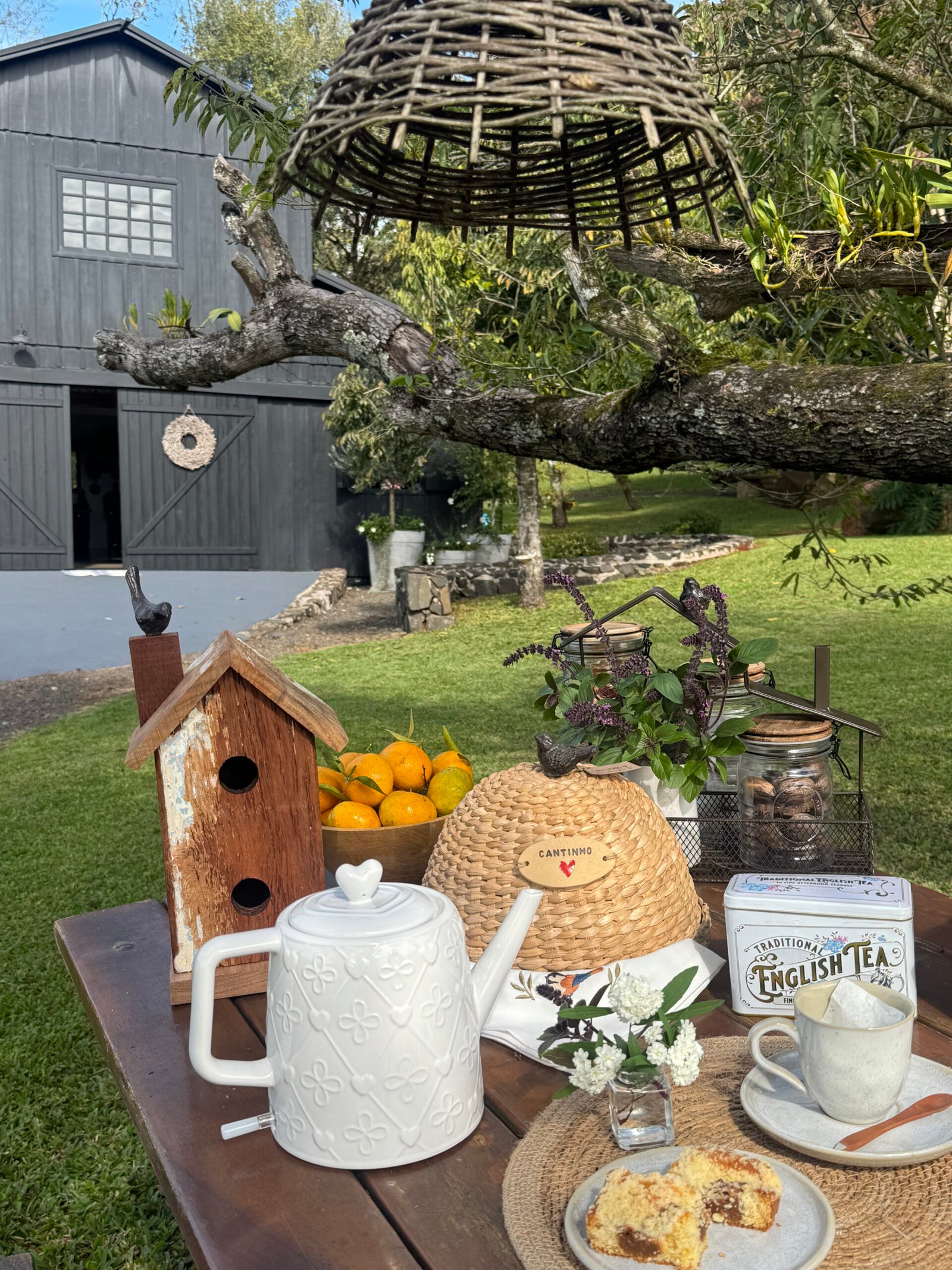 Composição externa com chá, casa de passarinho e produtos Cantinho do Coração